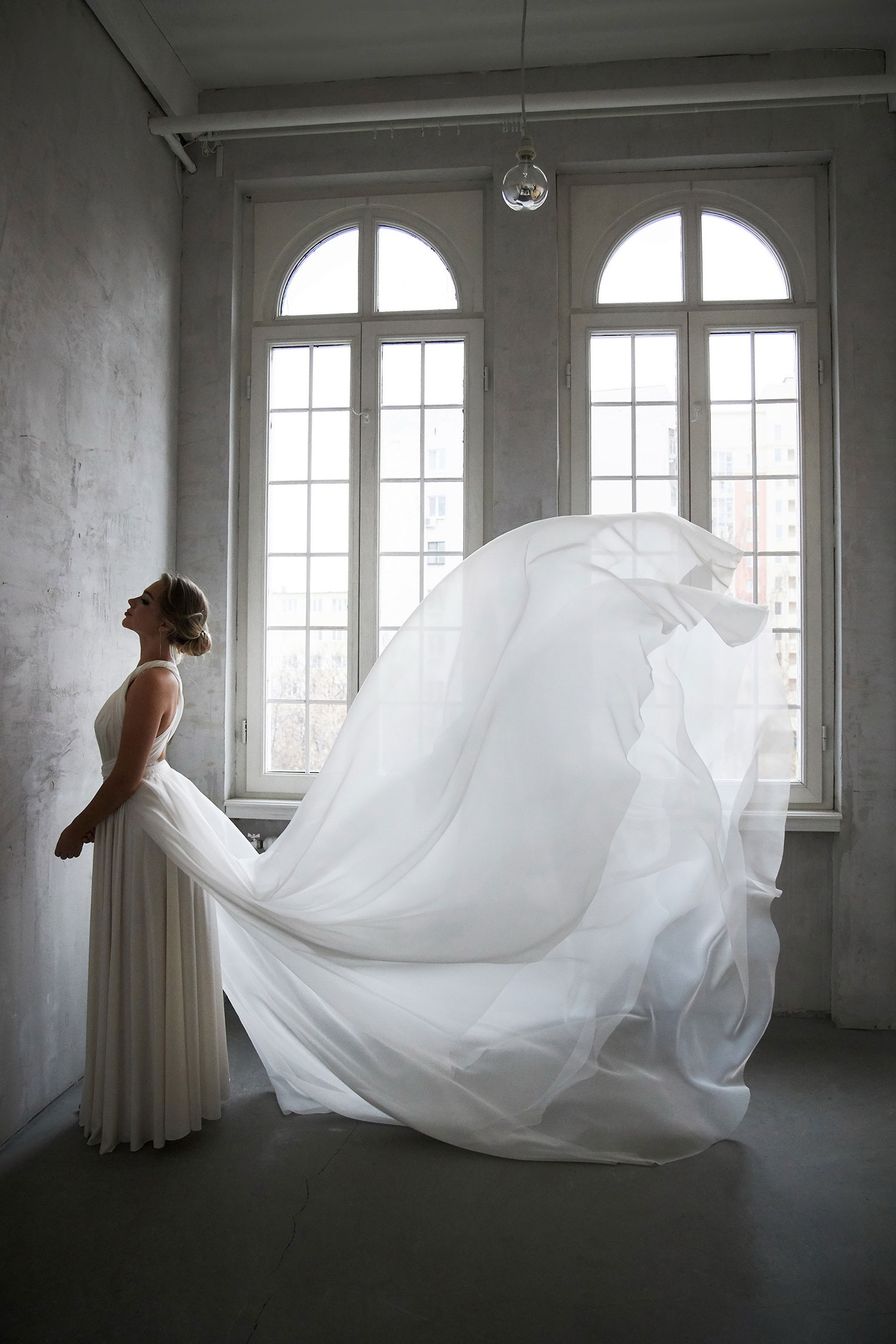 Beautiful slender woman in white wedding dress, new collection of dresses for the bride. Noise, out of focus
